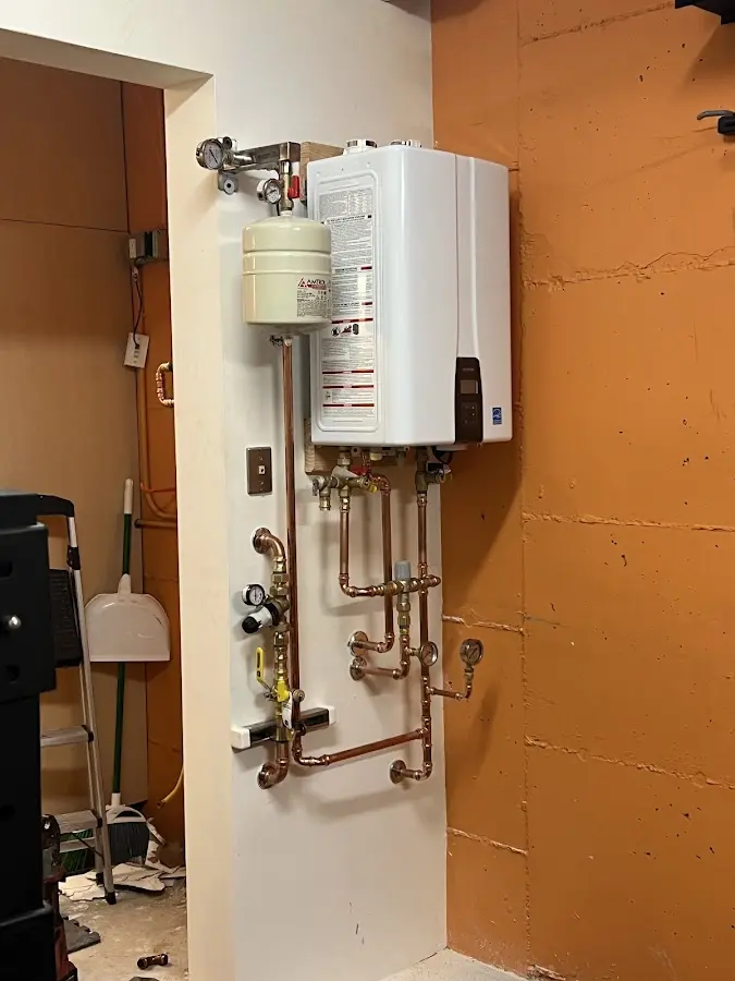 Plumbing technician inspecting water heater connections in Lampasas